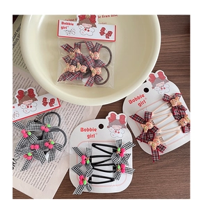 Detail of red and black checkered bow hair clip with cute resin bear and cherry charm