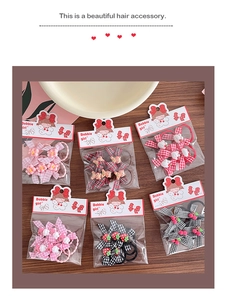 Close-up of cute cartoon bow hair clips set with bunny and strawberry charms