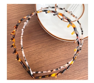 Close-up of tortoise shell and ink pattern resin headbands with non-slip teeth detail