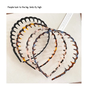 Detail view of four acetate hairbands with wavy teeth design in various trendy patterns
