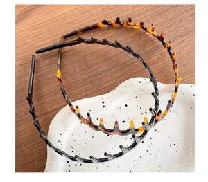 Detail view of wavy hairbands with teeth in black and tortoiseshell finish