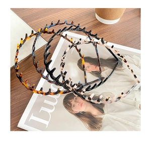 Detailed view of three tortoiseshell hair hoops with teeth set on a fashion magazine