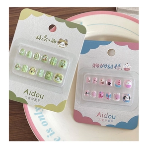 Close-up of children's 3D cartoon press-on nail sets featuring dog and dessert themes
