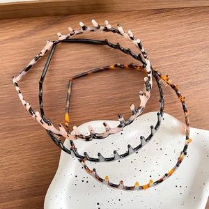 Set of three stylish wavy toothed headbands in tortoise, black, and marble patterns