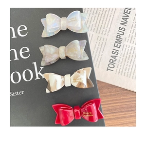 Détail de quatre barrettes nœuds en acétate avec inscription dorée France Handmade chic