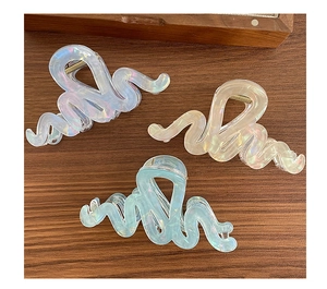 Détail de pinces à cheveux ondulées irisées en lavande, or champagne et vert menthe