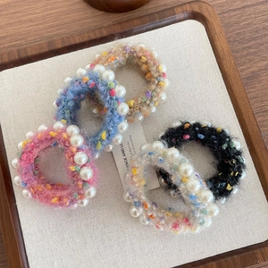 Élastiques à cheveux tricotés colorés avec perles synthétiques sur plateau en bois