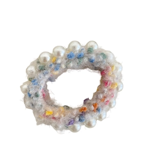 Chouchou en tricot crème avec pompons colorés et élégantes décorations de perles blanches