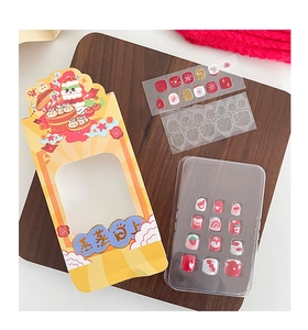 Detail of New Year children nail art kit with festive cartoon patterns and orange gift box