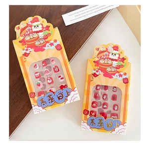Macro detail of New Year cartoon nail patches in festive red and yellow themed packaging