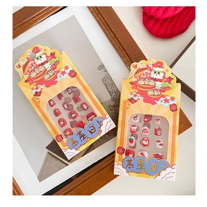 Detail of Lunar New Year themed kids press-on nails with cartoon buns and festive patterns