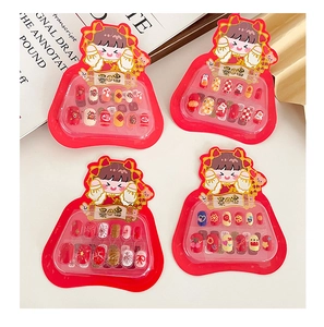 Detail view of colorful cartoon New Year press-on nail kits with traditional festive patterns