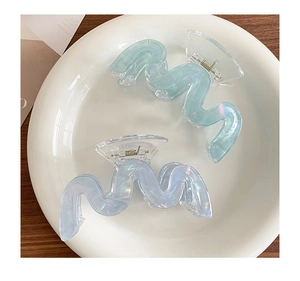 Dettaglio di pinze per capelli iridescenti in acrilico blu e viola con molla in metallo