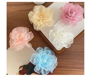 Detail von fünf Organza-Blumen-Haarspangen mit Kunstperlen in zarten Pastellfarben