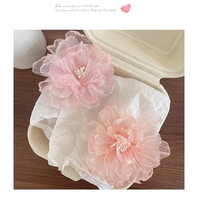 Detailansicht von zwei rosa Organza-Blumenhaarklammern mit zarten Perlen in der Mitte