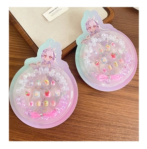 Detail eines DIY-Schmucksets für Kinder mit bunten Acrylperlen und Cartoon-Anhängern