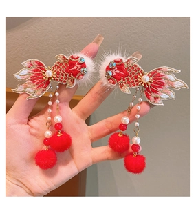 Détail de barrettes du Nouvel An chinois avec broderie de poisson rouge et pompons rouges