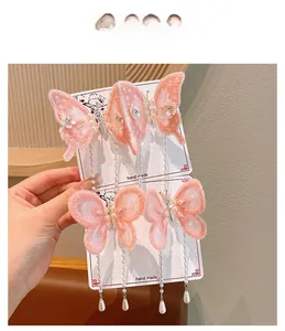 Détail de pinces à cheveux papillon brodées roses avec de jolies franges en perles