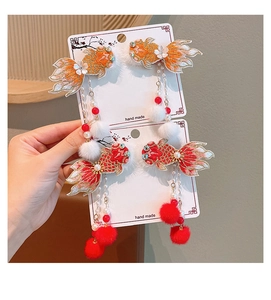 Détail de barrettes poisson rouge faites main avec broderies, pompons et glands rouges