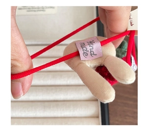 Détail de l'élastique à cheveux avec corde rouge extensible et étiquette de fabrication