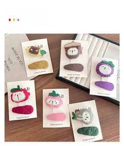 Detail of embroidered cartoon hair clips featuring bear, strawberry, and fruit shapes