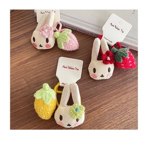 Détail d'un élastique à cheveux lapin et fraise fait main sur surface en bois