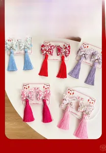 Dettaglio di fermagli per capelli a farfalla con paillettes colorate e lunghe nappe