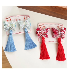 Dettaglio delle clip per capelli a farfalla in stile cinese con nappe e ricami luminosi