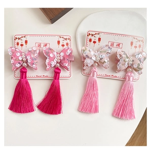 Dettaglio di fermagli per capelli a farfalla fatti a mano con nappe e paillettes