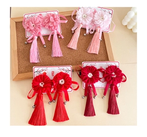 Détail de quatre paires de pinces à cheveux fleurs au crochet avec glands et clochettes