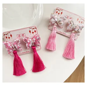 Dettaglio di fermagli per capelli a farfalla stile cinese con nappe rosa e paillettes