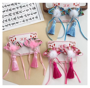 Detailed view of Chinese fan-shaped hair clips with silk tassels and soft pom-poms