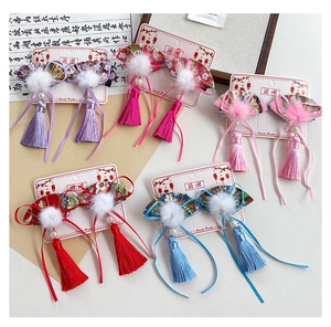 Detailed close-up of 5 pairs of Chinese fan-shaped tassel hair clips for girls on cardboard