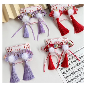 Detail of four sets of Chinese fan hair clips with tassels and plush pom-poms for girls