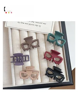 Vue détaillée de six mini pinces à cheveux mates en couleurs variées sur plateau velours