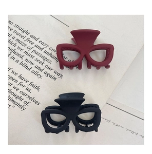 Détail de pinces à cheveux mates rouges et noires avec design unique de monture de lunettes