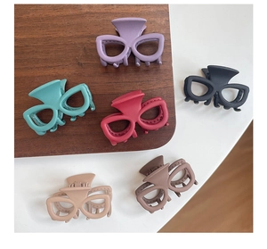 Vue à plat de six pinces à cheveux mates en forme de lunettes aux tons Morandi