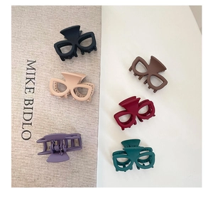 Détail de six pinces à cheveux mates aux couleurs variées avec forme de lunettes tendance