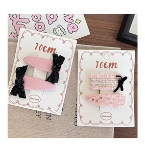 Detail view of handmade pink fabric hair clips with tweed bows and pearls for girls