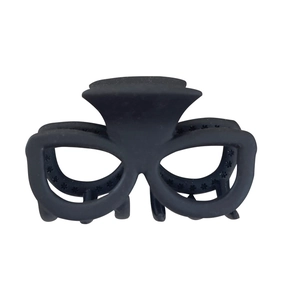 Pince à cheveux noire mate en forme de lunettes pour queue de cheval sur fond blanc