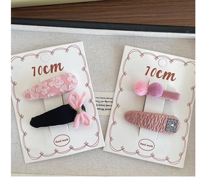 Detail of pink and purple fabric hair clips with lace flowers and knit bows for girls