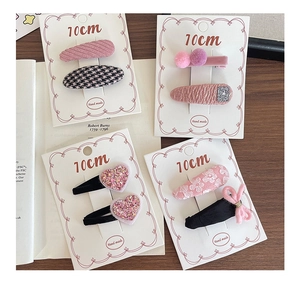 Detail of pink fabric hair clips with diverse textures and patterns for girls