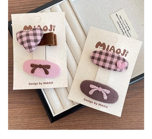 Détail d'un lot de 4 barrettes à cheveux pour filles avec nœud et cœur sur carte