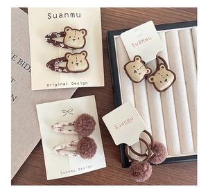 Dettaglio di fermagli ricamati con orsetto ed elastici floreali in set regalo