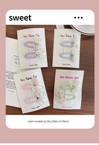 Detail showing four sets of pastel pearl flower and bow hair clips on display cards