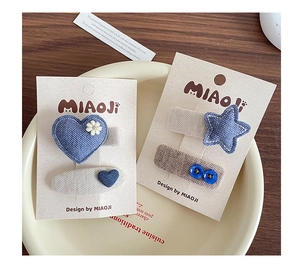 Detailed shot of handmade blue denim heart and star fabric hair clips for girls