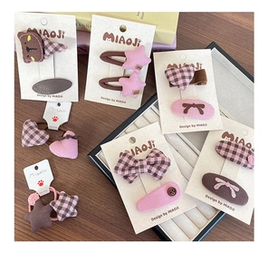 Vue détaillée des pinces à cheveux à nœuds roses et élastiques sur carton