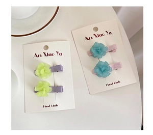 Detail of sweet floral hair clips with multilayer petals and satin-wrapped metal bases