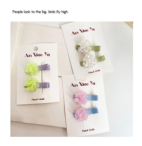 Detail of colorful multilayer chiffon flower hair clips on a white display card