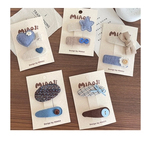 Detailed set of cute blue fabric hair clips with bows and hearts on craft cards